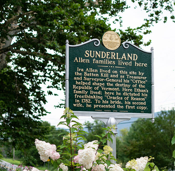 Allen Family historic marker with blooming hydrangea in the front of the inn